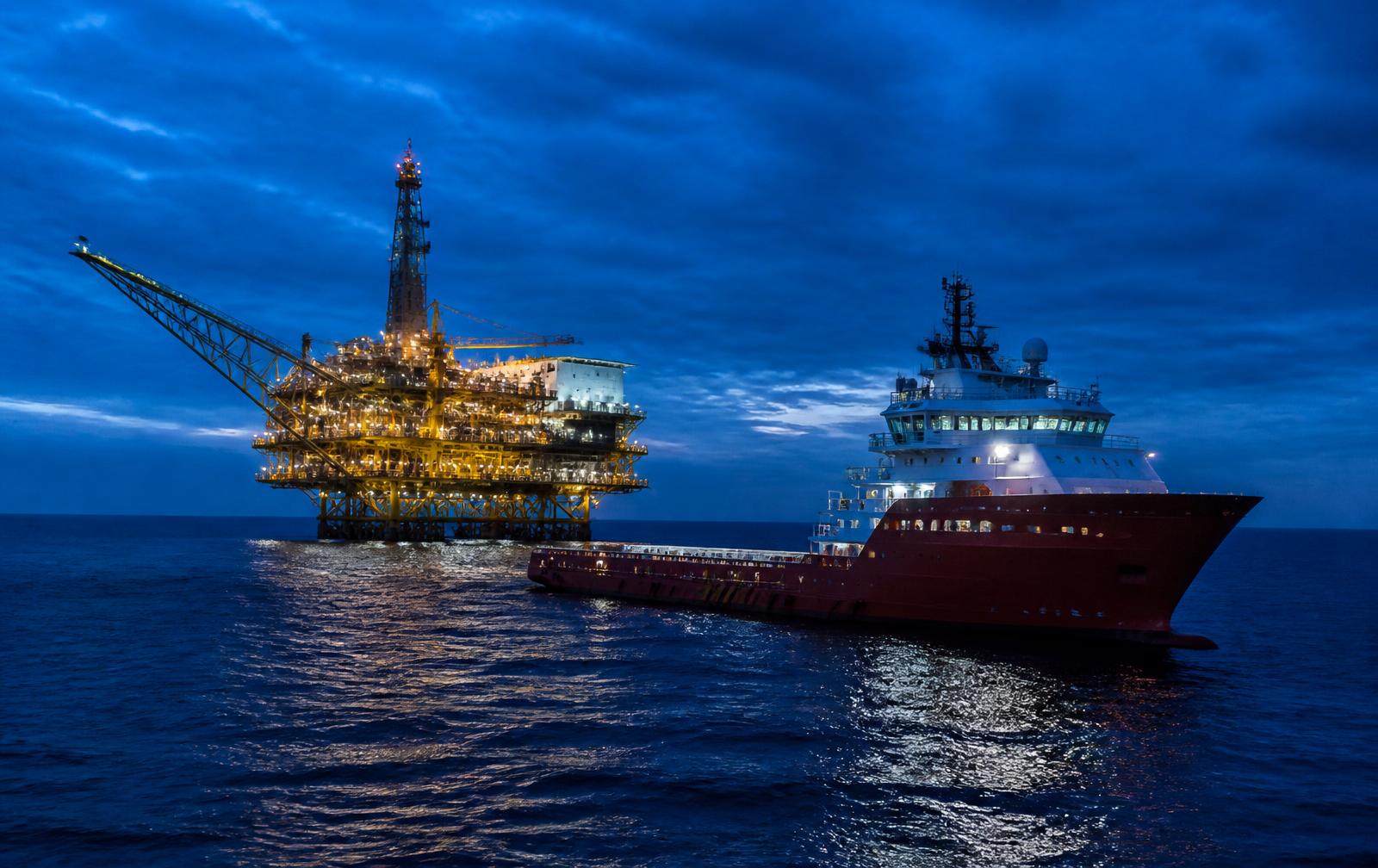 Offshore platform and supply vessel at blue hour